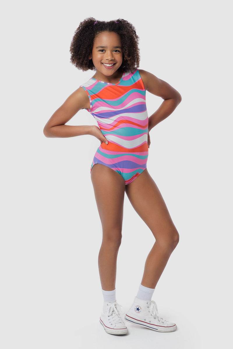 Photo of a 5 year old girl, standing iPhoto of a 10 year old girl standing infront of a white backdrop. Wearing a wavy pattern gymnastics leotard that is a mix of purple, aqua, white & purple. There are no crystals, making it great for training.