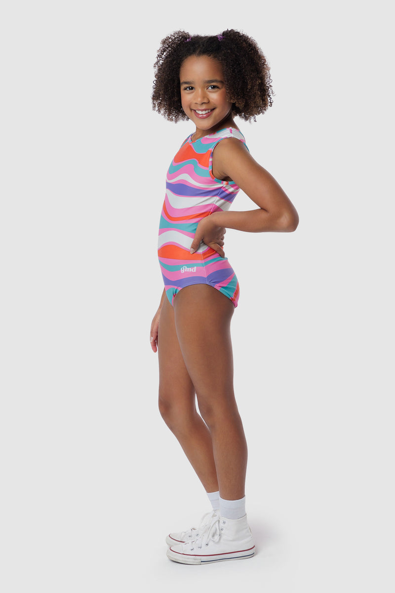Photo of a 5 year old girl, standing iPhoto of a 10 year old girl standing infront of a white backdrop. Wearing a wavy pattern gymnastics leotard that is a mix of purple, aqua, white & purple. There are no crystals, making it great for training.