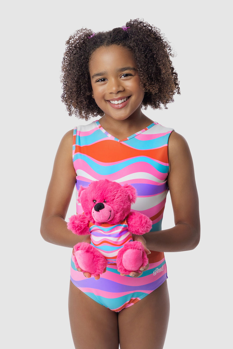 Photo of a 5 year old girl, standing iPhoto of a 10 year old girl standing infront of a white backdrop. Wearing a wavy pattern gymnastics leotard that is a mix of purple, aqua, white & purple. There are no crystals, making it great for training.