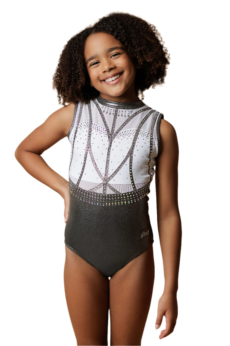 Girl staning infront of a beige background, wearing a white & gunmetal grey gymnastics leotard. The top half of the letoard is white and is not see through. It is encrusted with crystals and features gunmetal grey shiny applique detailing. The lower half is shiny gunmetal mystique fabric. Fully lined.