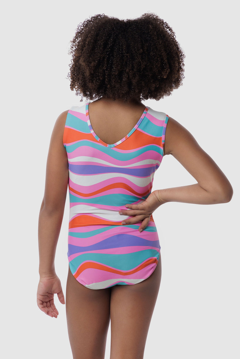 Photo of a 5 year old girl, standing iPhoto of a 10 year old girl standing infront of a white backdrop. Wearing a wavy pattern gymnastics leotard that is a mix of purple, aqua, white & purple. There are no crystals, making it great for training.