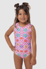 Photo of a 5 year old girl, standing infront of a white backdrop. Wearing a patterned leotard that has pink & white checkers with green, orange & purple flowers ontop. There are no crystals, making it great for training.